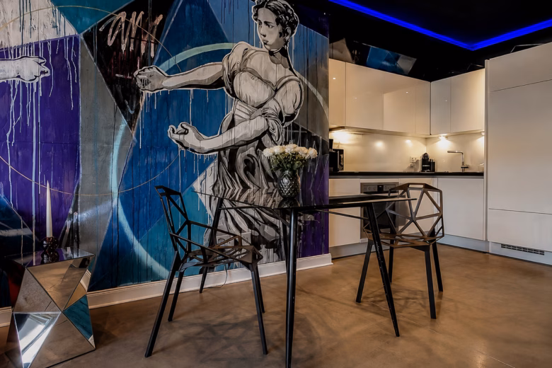 Dining area in the Executive Design Loft Heidelberg with modern kitchen and statement mural