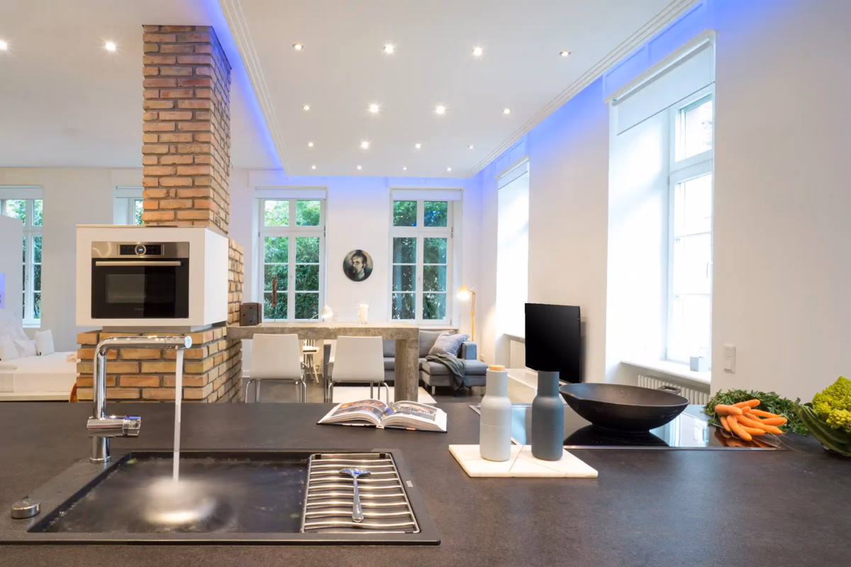Modern open kitchen with brick details and dining area in the Grand Superior Loft