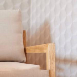 Interior detail at Boutique Suites and Residences Heidelberg with oak armchair and textured wall design – elegant and modern atmosphere