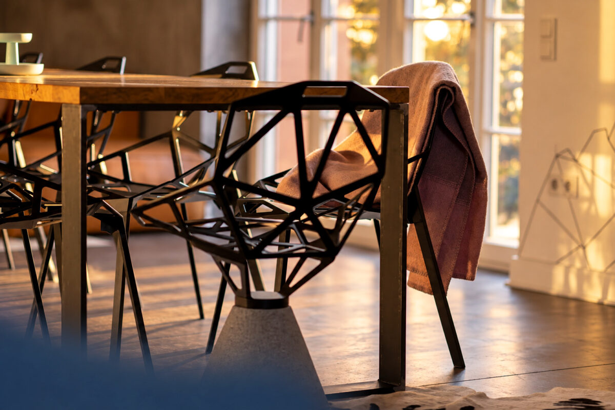 Designer dining chairs and dining table in the Grand Loft Residence Heidelberg at sunset