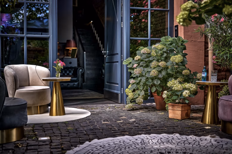 Private hotel entrance with elegant lounge seating and flowers at Boutique Suites and Residences Heidelberg.