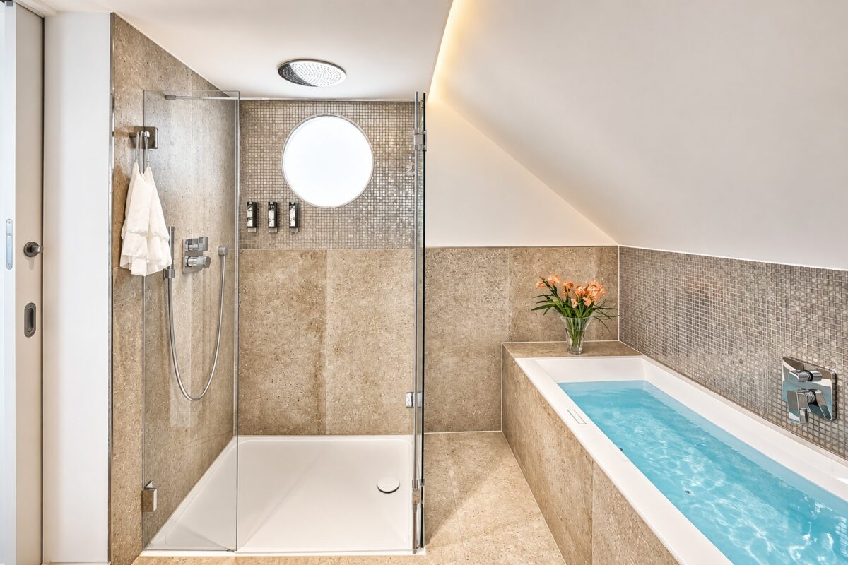 Spa-inspired master bathroom in the Penthouse Royal at Boutique Suites and Residences Heidelberg with rain shower, whirlpool bath, and luxury stone design