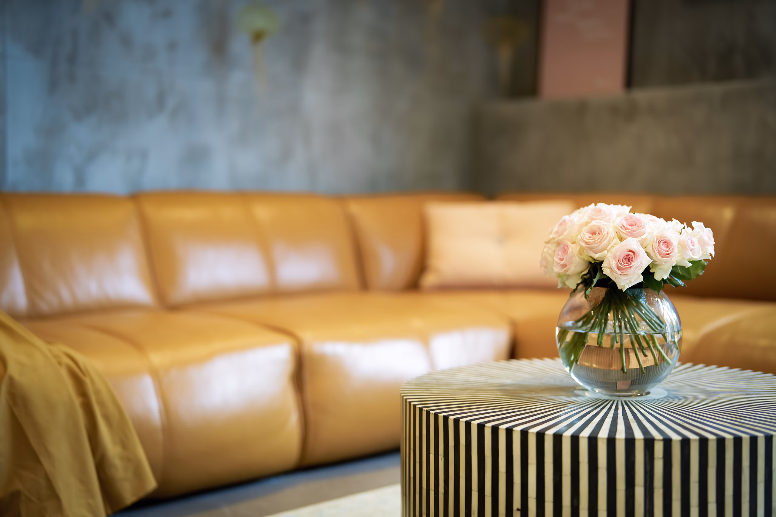 Elegant living room detail in the Grand Superior Suite Heidelberg with leather sofa and fresh flowers – luxurious atmosphere for extended stays.