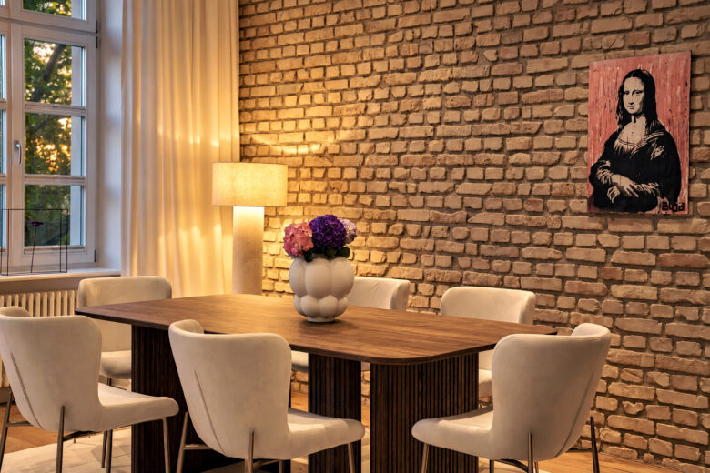 Dining area in the Signature Two-Bedroom Residence Heidelberg with exposed brick wall and warm evening light