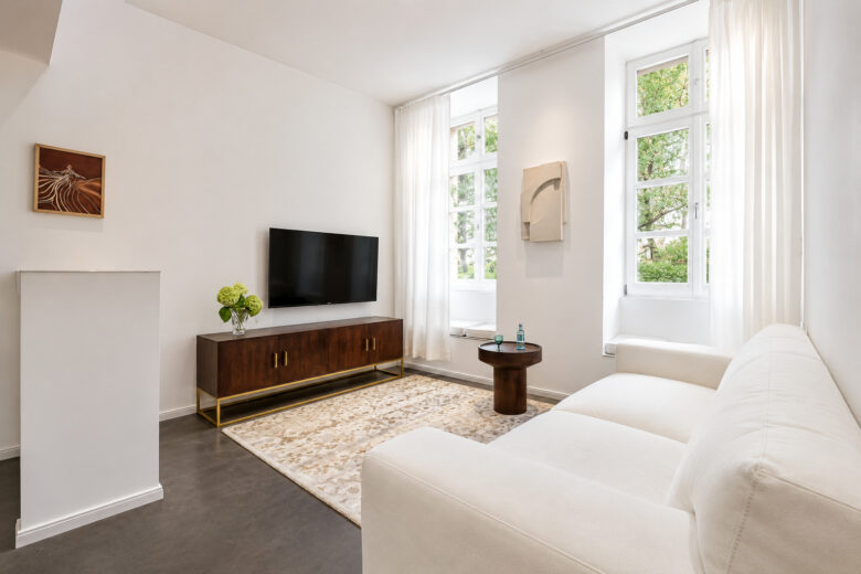 Bright private living area with sofa and TV in the Business One-Bedroom Residence Heidelberg