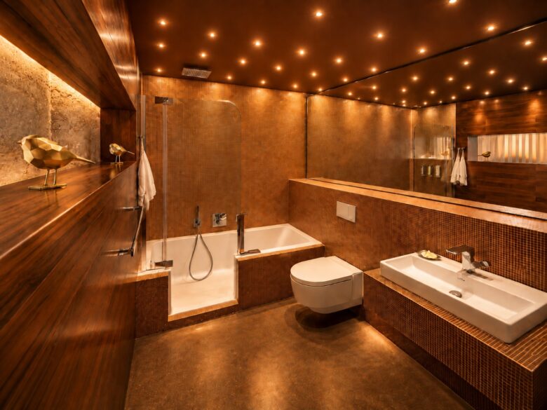 Spa-style bathroom of the Business One-Bedroom Residence Heidelberg with bathtub, mosaic surfaces and warm evening light