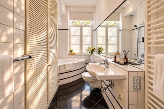 Bright private bathroom in the Family Apartment Heidelberg with bathtub, white pleated blinds and soft natural light.
