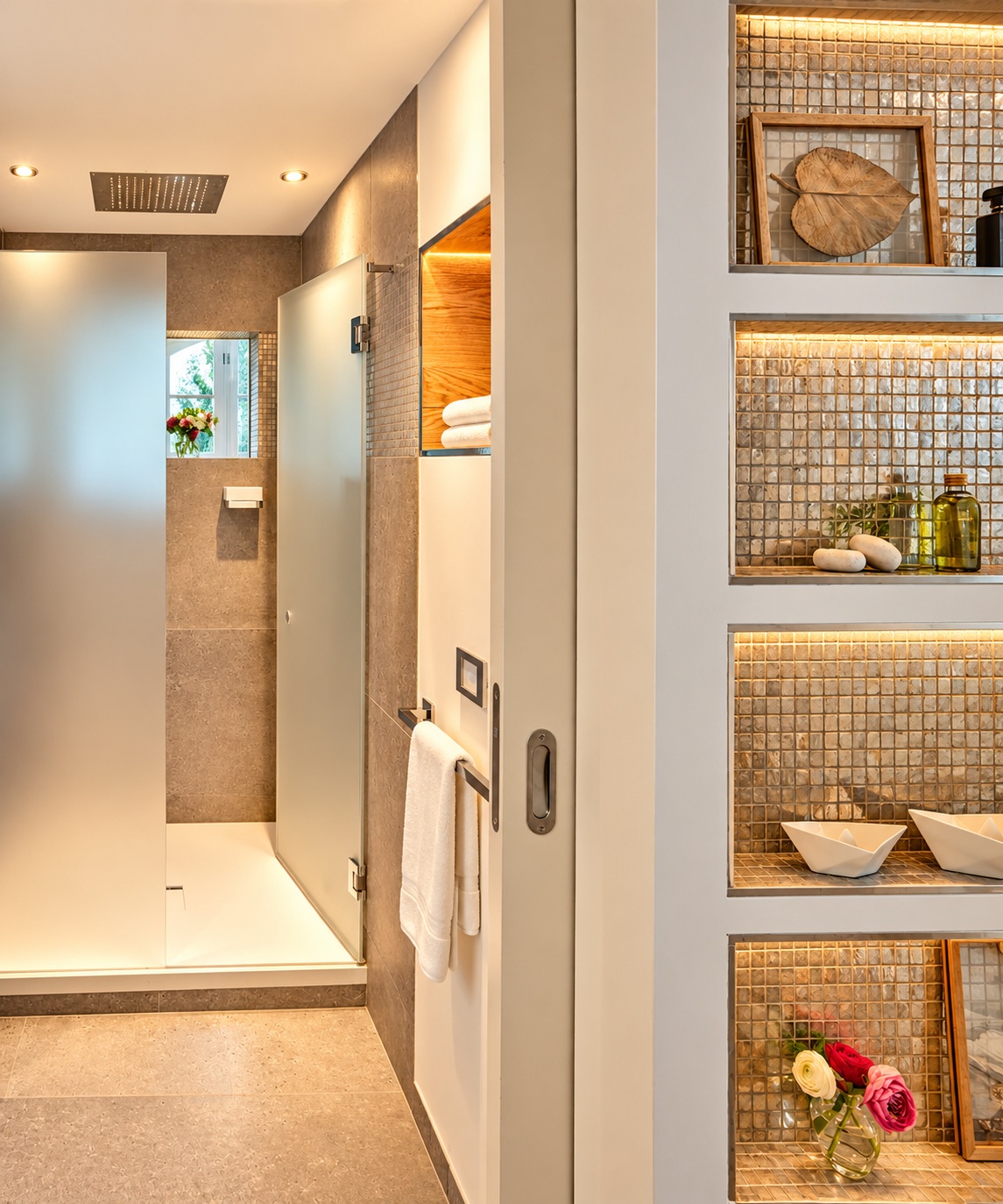 Elegant spa shower in the Panorama Whirlpool Penthouse Heidelberg with rainfall shower, illuminated niches, warm stone surfaces and refined bathroom details