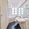 Bright family apartment bathroom with bathtub, shower, and large mirror – ideal for long-term stays in Heidelberg