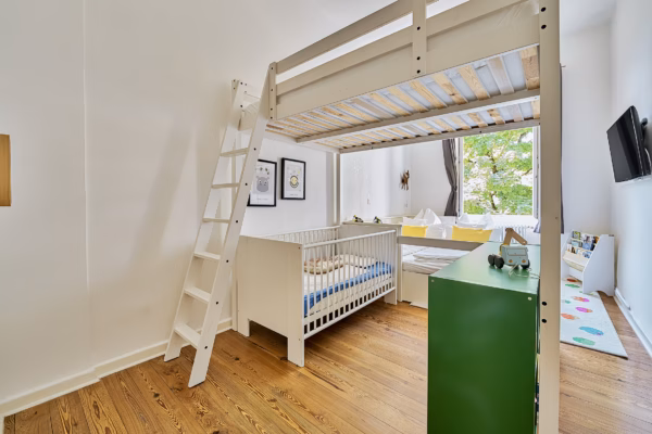 Bright children’s room with loft bed, crib, and play area – ideal for long-term family stays in Heidelberg