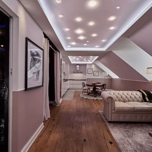 Stylish Superior Suite with slanted ceilings, a comfortable sofa, dining area, and modern lighting design in Heidelberg.