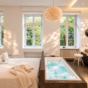 Open-plan bedroom and living area with private in-room whirlpool in the Executive Loft Residence Heidelberg