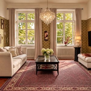 Elegant private living area of the Grand Two-Bedroom Residence Heidelberg with crystal chandelier and large windows