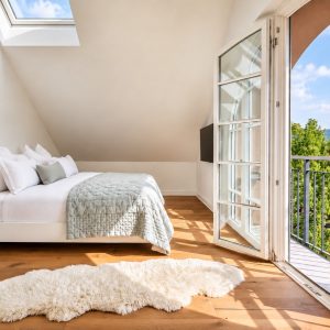 Penthouse Royal master bedroom at Boutique Suites and Residences Heidelberg with king-size bed, balcony, and panoramic city views
